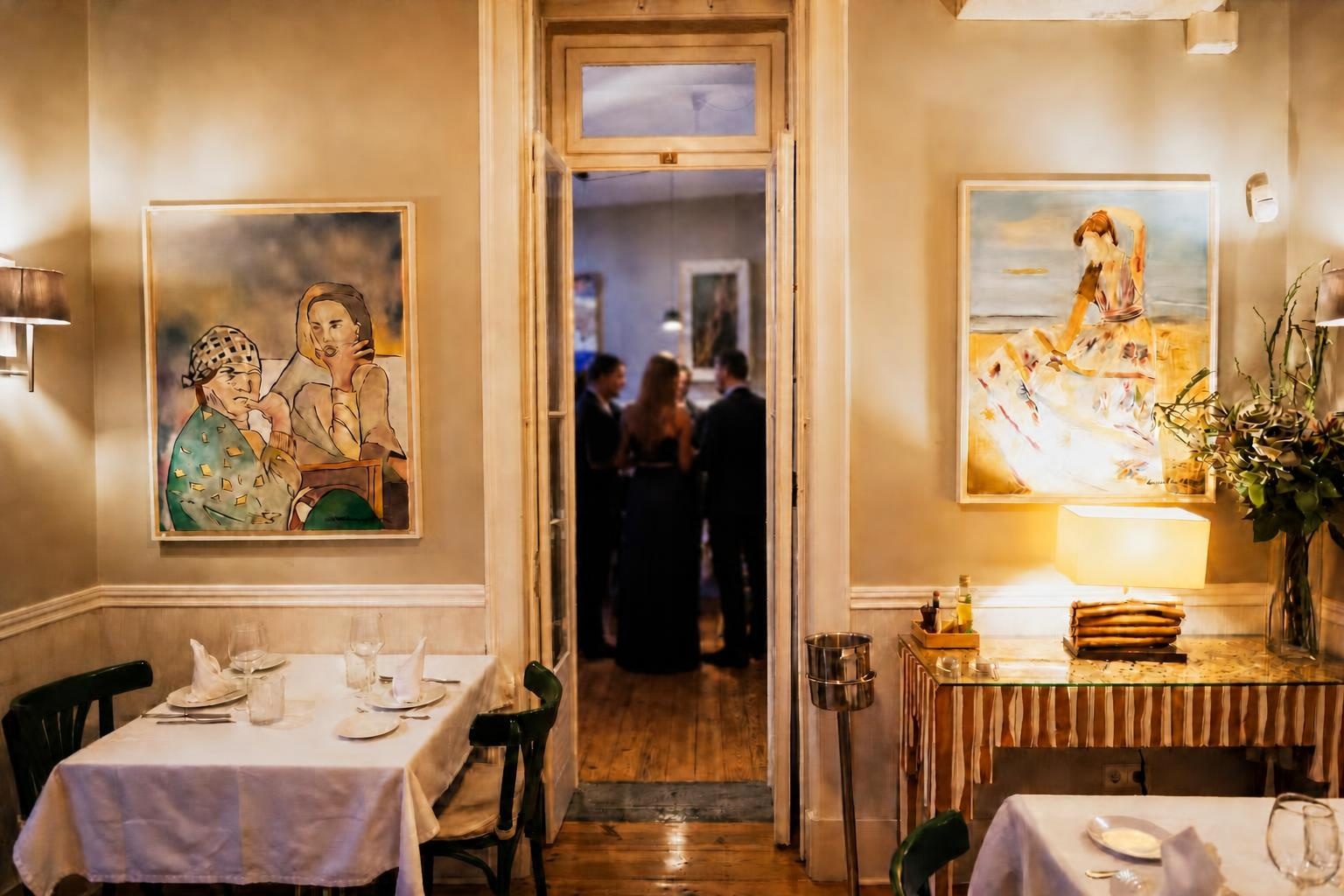 An open doorway between two set dining rooms at Villa Sabóia